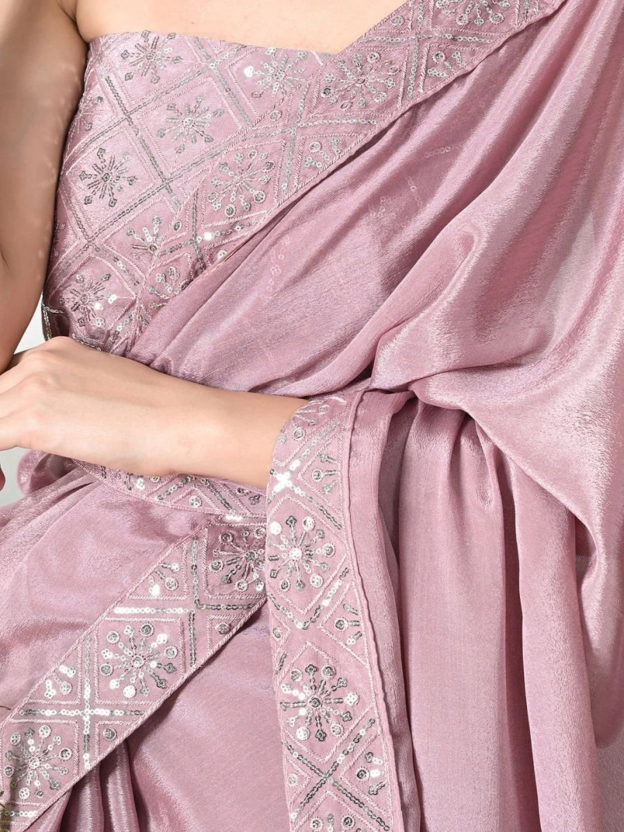 Close-up of a pink saree with intricate silver embroidery.