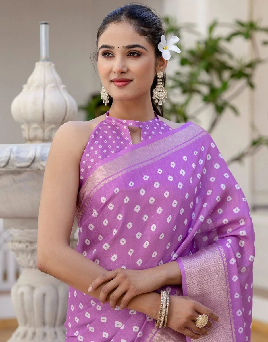 Woman wearing a purple saree with white patterns