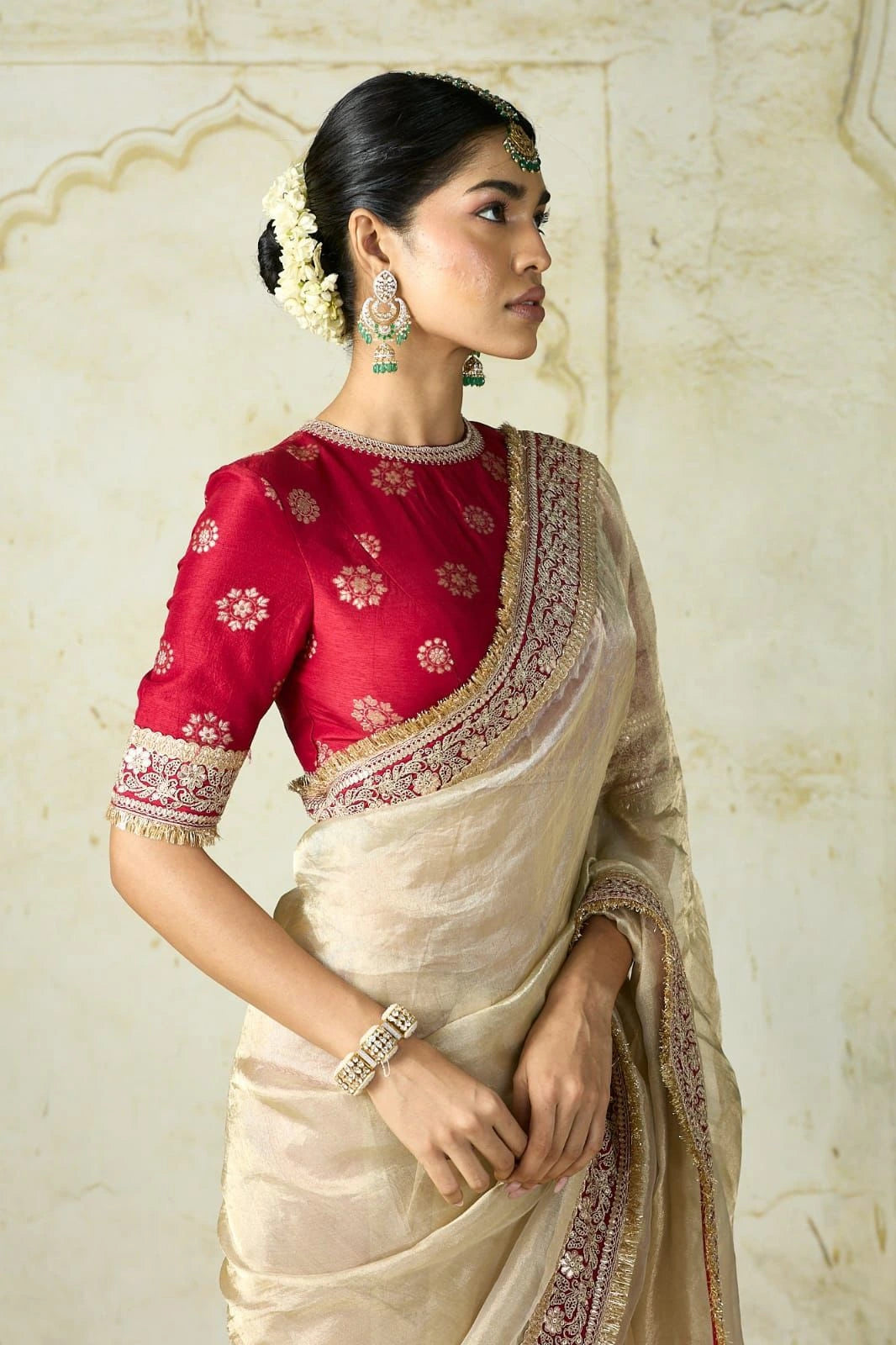 Fulari beige golden festive saree paired with a red designer blouse.