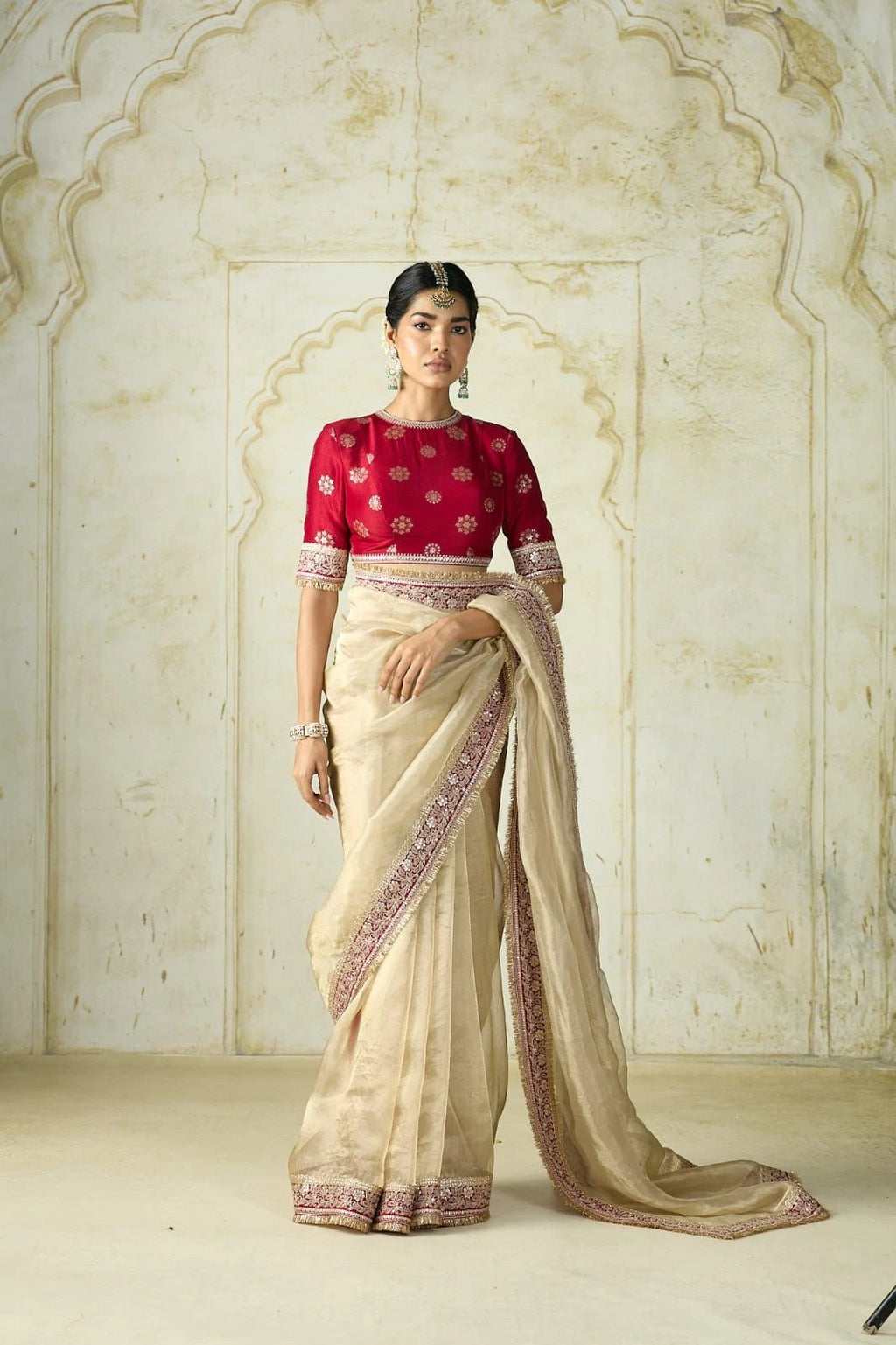 Fulari heritage-inspired golden saree with red embroidered blouse.