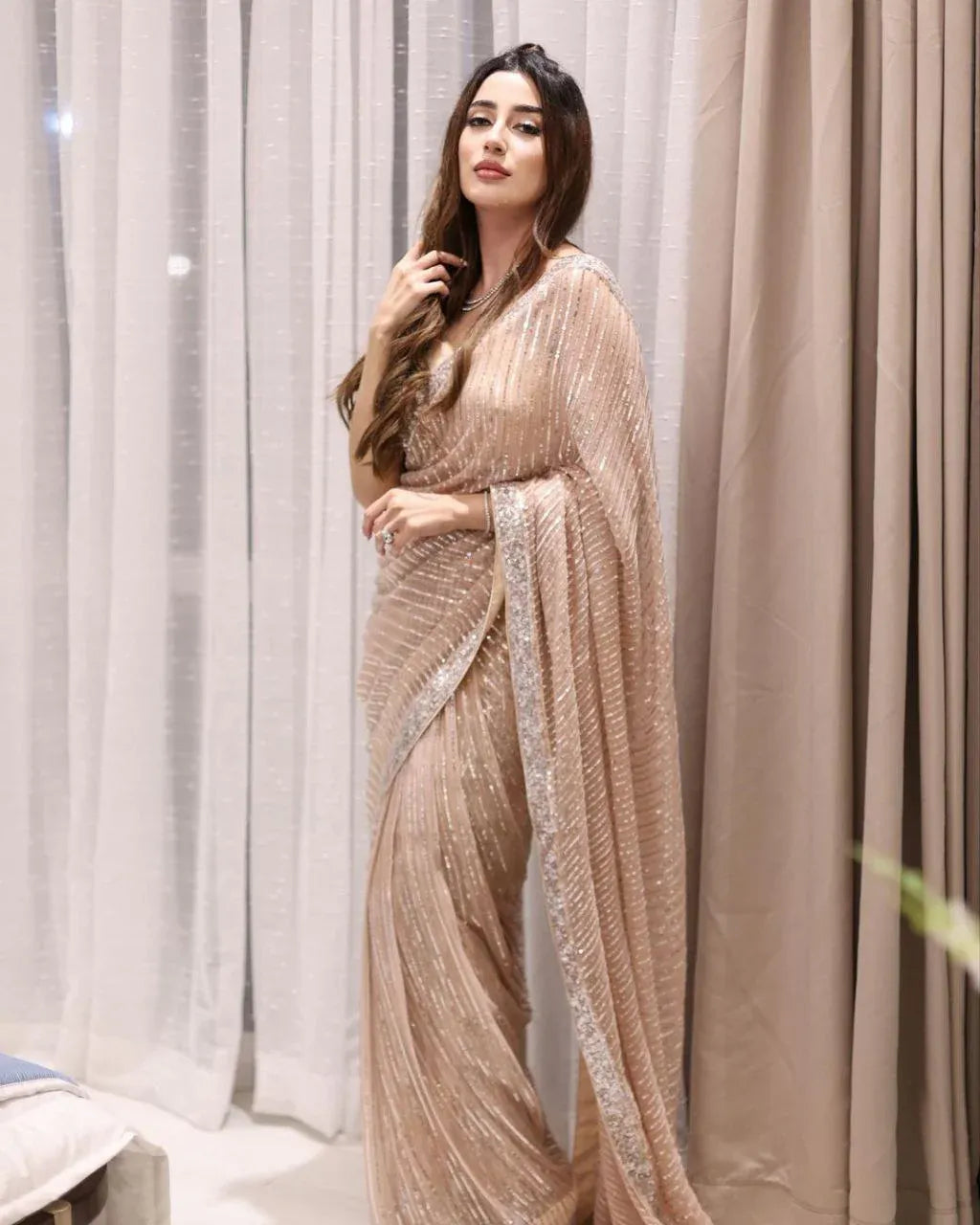 Peach wedding guest saree by Fulari with shimmering fabric and elegant drape
