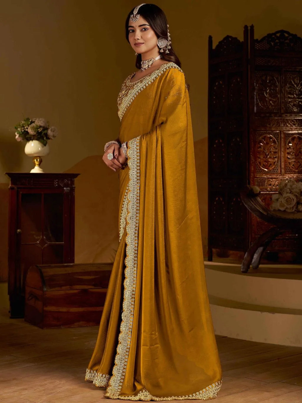 Traditional gold partywear saree by Fulari with heavy embroidered blouse and elegant drape